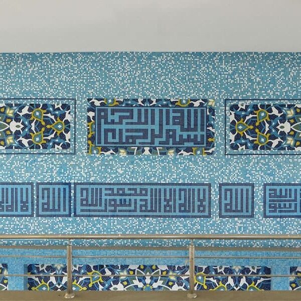 Floral Persian pattern with Kufic Islamic Calligraphy and blue glass mosaic random mixing tiles. Mosque wall cladded Custom handmade ornamental tiles by MEC.