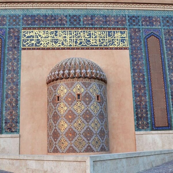 Arabic Calligraphy depicting Holy verses in 24K Gold foiled Glass Mosaic Tiles installed at Katara Cultural Village Mosque Doha. Custom Islamic pattern glass mosaics cladded on Mehrab.