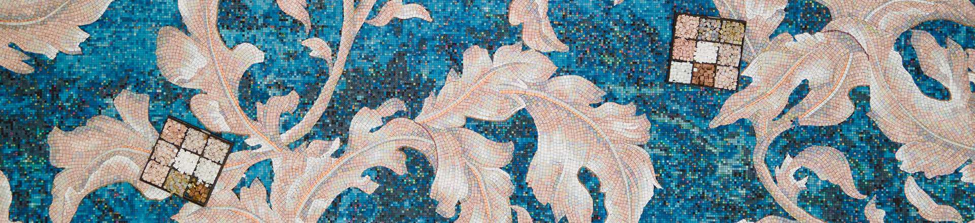 Blue mosaic background with large cream floral pattern and sample tiles placed on the surface.