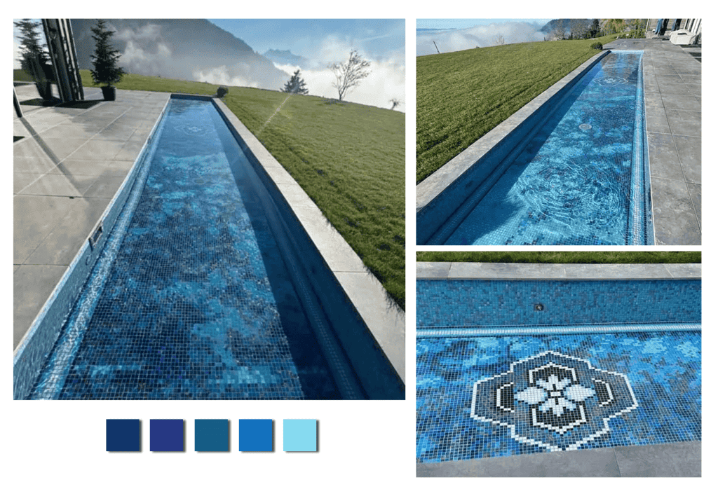 Long mosaic swimming pool with blue gradient tiles and floral medallion, overlooking scenic grassy hilltop.