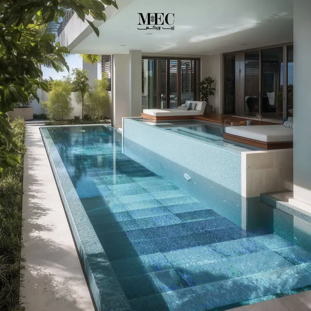 A rectangular swimming pool designed with blue gradient mosaic tiles, featuring a sleek modern layout, light stone surroundings, and a cozy lounge seating area.