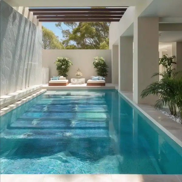 Clear view of a swimming pool featuring a rectangular design with shimmering blue water and mosaic pool tiles forming a geometric pattern.
