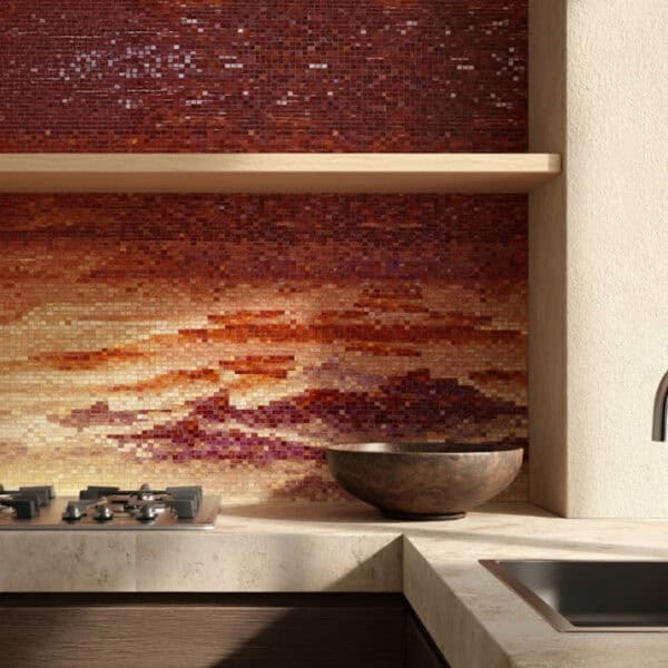 Amber Dusk Mosaic Kitchen backsplash with a gradient mosaic of red, copper, and gold tones resembling a glowing sunset, complemented by natural stone countertops and wooden accents.