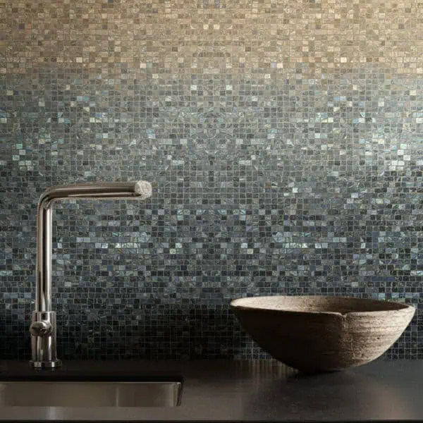 Midnight Dune Mosaic backsplash featuring a gradient mosaic transitioning from warm beige to dark graphite tones, paired with a chrome faucet and stone bowl on a black countertop.
